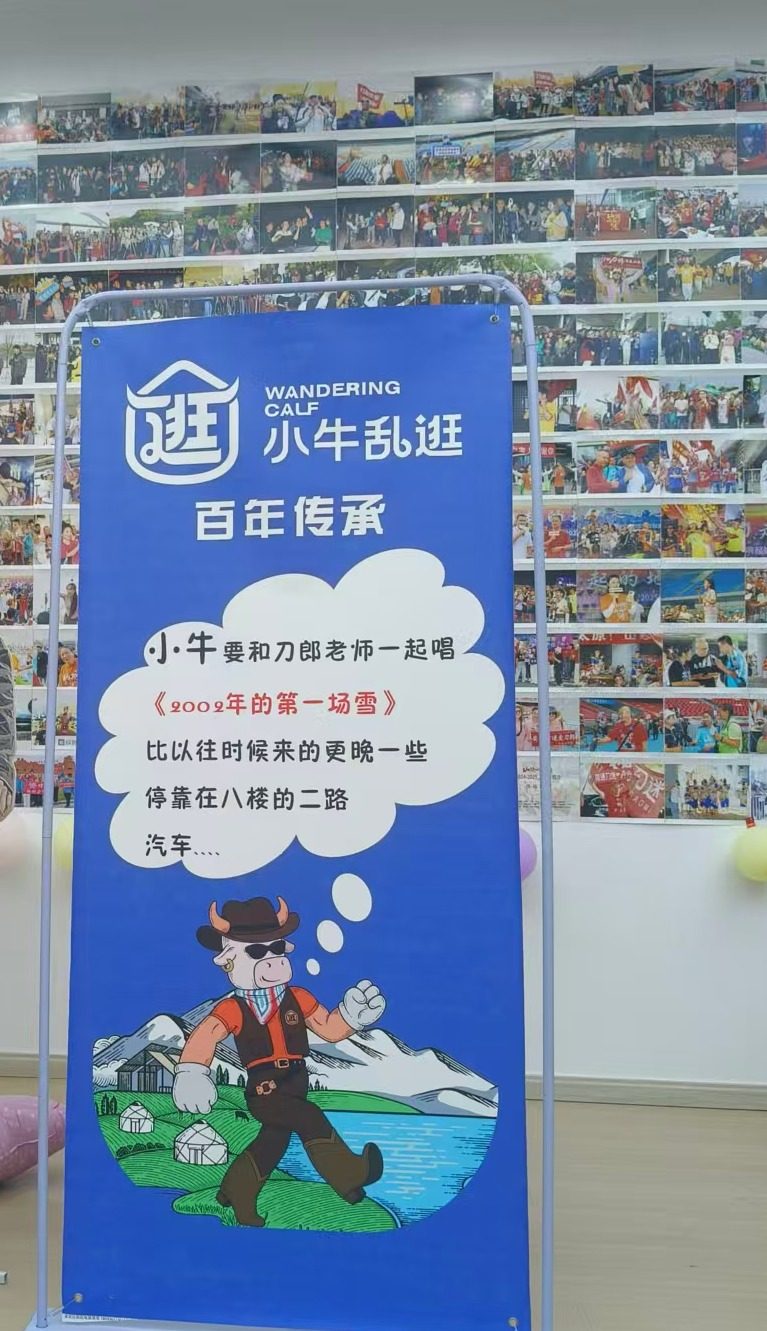 乌鲁木齐刀迷驿站内，小牛乱逛的蓝色立牌立在整面合影照片墙前
