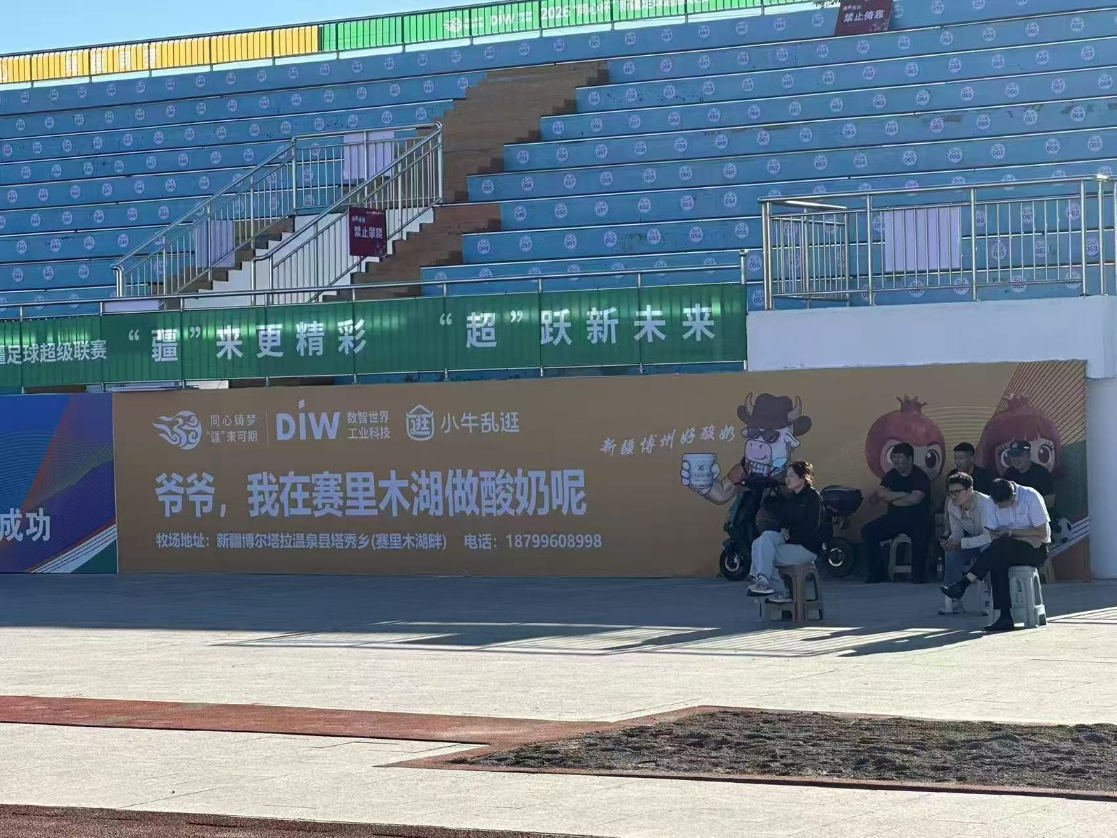 疆超联赛博州主场看台广告牌：爷爷，我在赛里木湖做酸奶呢