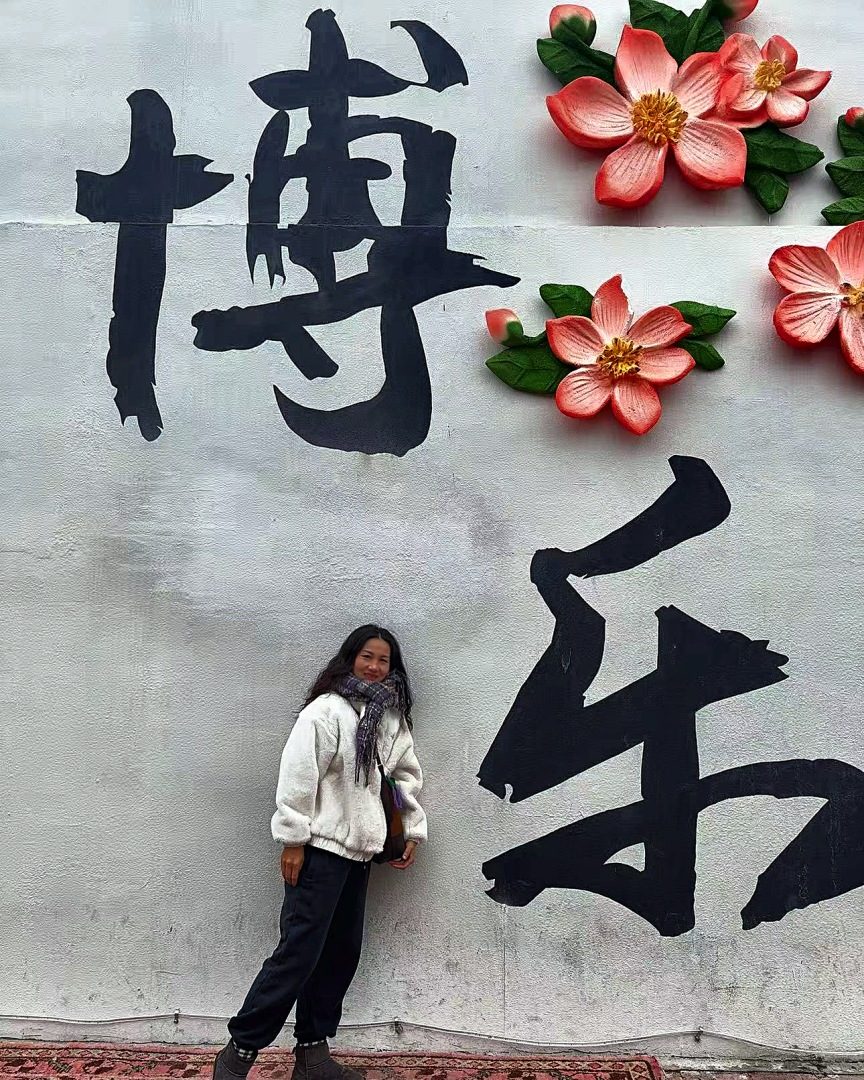 李妍在团场「博乐」大字墙前。