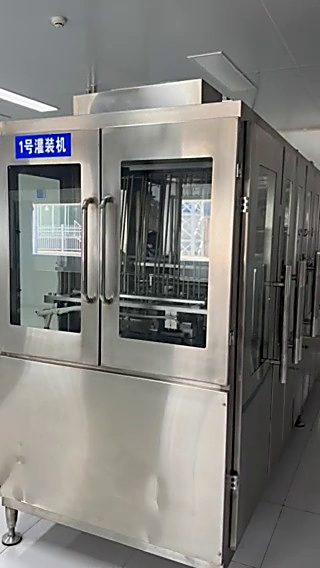 1 号灌装机。机身标牌写着"1号灌装机"，玻璃门内是灌装机构与输送链。